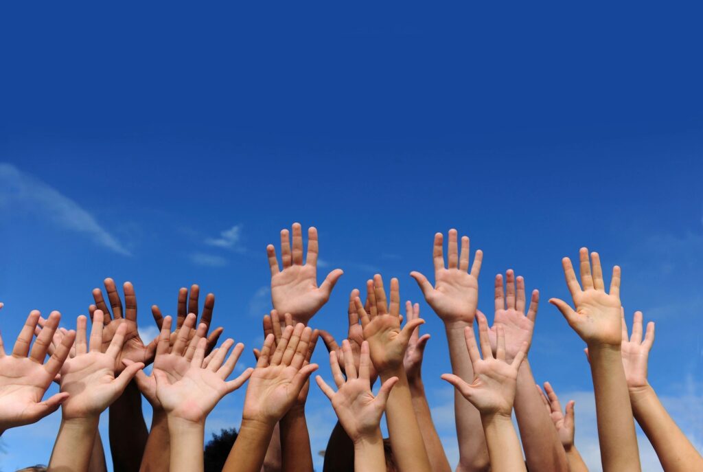 a picture of a blue sky with many hands raised up