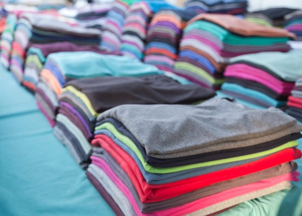a picture of several stacks of folded t-shirts