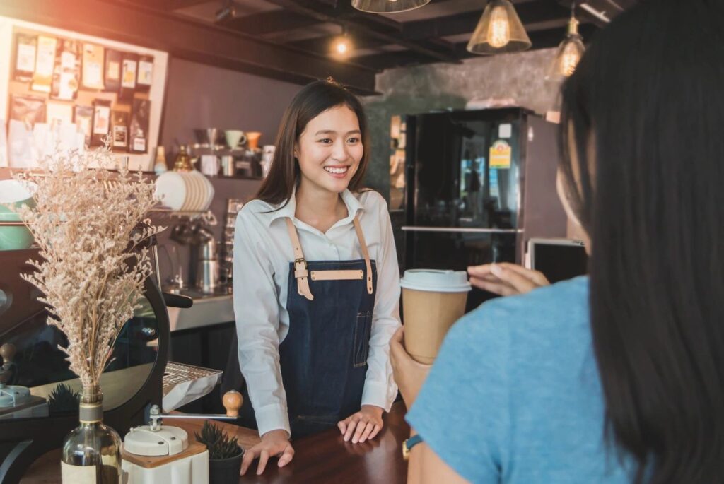 a picture of an employee wearing an apron in a coffee shop
