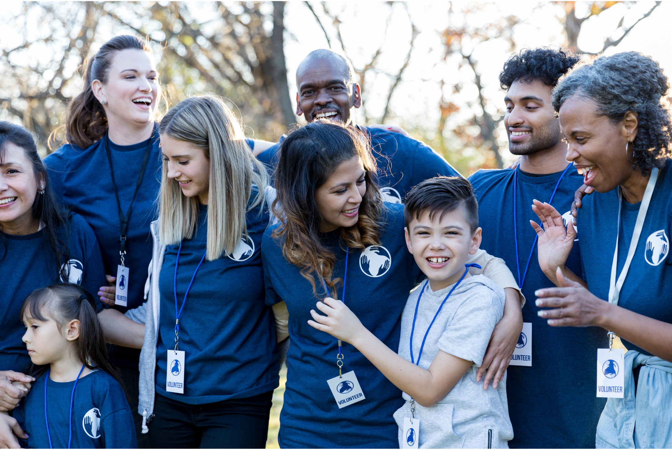 a group of people wearing matching shirts praising a child fo his success
